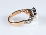 an image of a gold ring with black and white diamonds