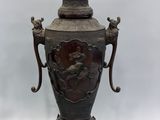 a large bronze vase with two handles on a stand