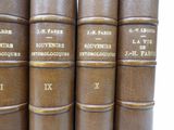 several old books are stacked on top of each other on a shelf