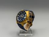 yellow and blue watch on a clear stand on a gray surface