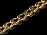 a close up of a gold chain on a black background