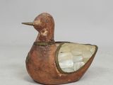 une image représentant un petit canard en bois posé sur une table