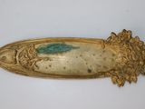 une assiette en or ornée d'un motif vert
