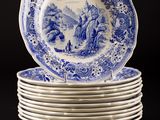 blue and white plates stacked on top of each other on a black surface