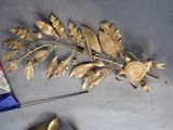 a gold leaf decoration on the floor next to a pair of scissors