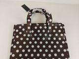 sac à pois marron et blancs, orné d'une étiquette noire