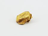 a close up of a piece of gold on a white surface