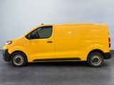 the yellow van is parked in a parking lot on a cloudy day