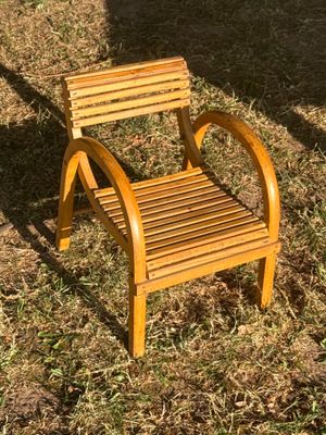 une chaise en bois posée dans l'herbe