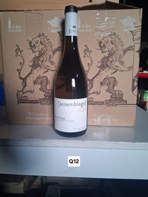 a bottle of wine sitting on a shelf next to a box of wine