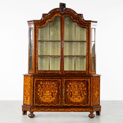 une vitrine ancienne en bois, dotée de portes vitrées et de tiroirs