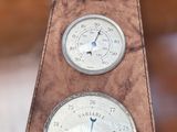 three different clocks hanging from the back of a wooden bench