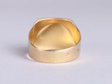 a close up of a gold ring on a white surface