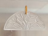 a close up of a pendant with a leaf design on it