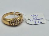 une bague en or sertie de trois diamants, avec une étiquette indiquant son prix