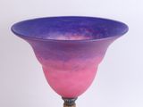 a purple and blue glass vase on a stand