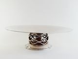 a glass cake stand with a silver plate on it