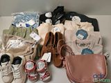 Plusieurs paires de chaussures, un porte-monnaie, un sac à main, un porte-monnaie et une paire de chaussures sont posés sur une table.