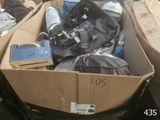 une boîte en carton remplie d'objets hétéroclites sur le sol