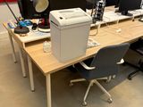 a desk with two computers and a printer on it