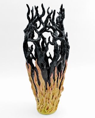 un vase noir et jaune dans lequel se trouvent de nombreuses branches