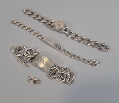 un bracelet en argent et une chaîne en argent posés sur une table