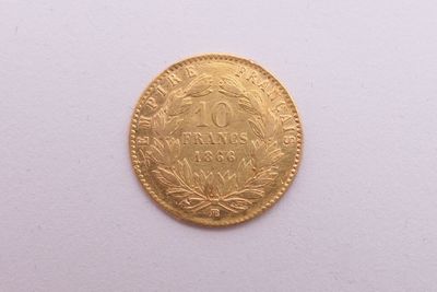gros plan d'une pièce d'or sur une surface blanche