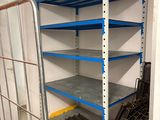a metal rack in the corner of a room with several shelves