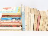 several books are stacked on top of each other on a white surface