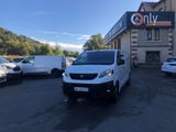 une camionnette blanche garée sur un parking à côté d'un bâtiment