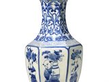 a blue and white vase with a lamp on top of it