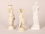 two white statues of women and a statue of a woman holding a vase