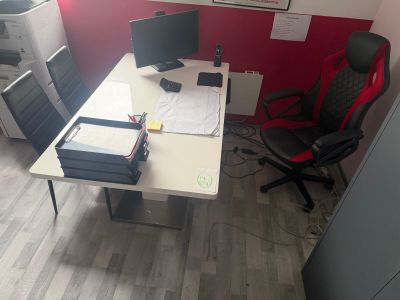 a desk with two computers and a printer on it