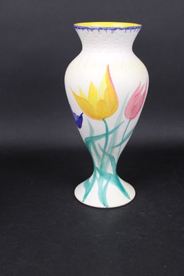 un vase blanc orné de fleurs peintes sur fond noir