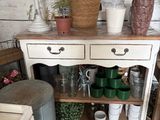 a small table with pots and vases on top of it
