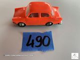une petite voiture orange avec une étiquette bleue dessus