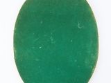 a close up of a green oval pendant on a white surface