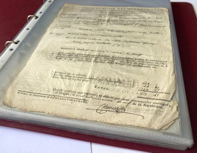 an old document sitting on top of a binder on top of a table