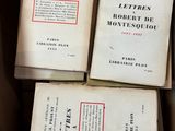 Plusieurs livres sont empilés les uns sur les autres dans une boîte.