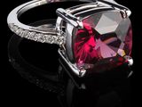 un gros plan d'une bague ornée d'une pierre rose entourée de diamants