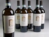six bouteilles de vin sont alignées sur une table