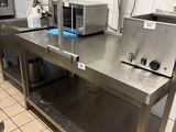 une cuisine équipée de plans de travail et d'appareils électroménagers en acier inoxydable