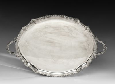 un plateau en argent avec des poignées et des poignées sur une surface blanche