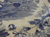 a blue and white plate with a bird and flowers on it