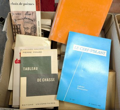 several books are stacked in a box on a table