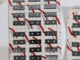 several pieces of white and black tile with red paint on them