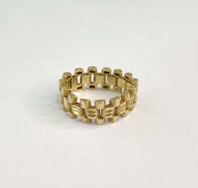 gros plan d'une bague en or sur une surface blanche
