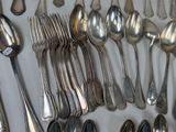 a lot of silver spoons and spoon spoons on the table