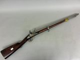 un fusil au canon en bois et aux garnitures en laiton, posé sur une surface blanche
