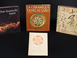 trois livres posés sur une table noire, sur lesquels figurent des caractères chinois